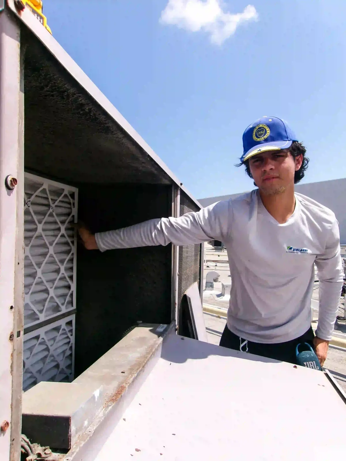 Pilar Services technician checking refrigerant pressures on an outdoor condenser
