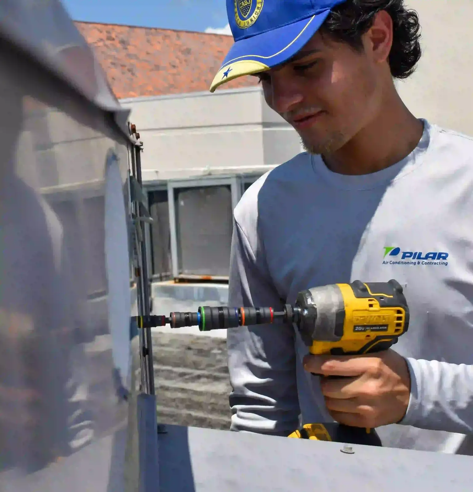 Pilar Services technician servicing a commercial ceiling A/C unit